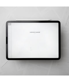 A tablet with a white background and small text in the center that says "Curiosity Journal". From Answer in Progress.