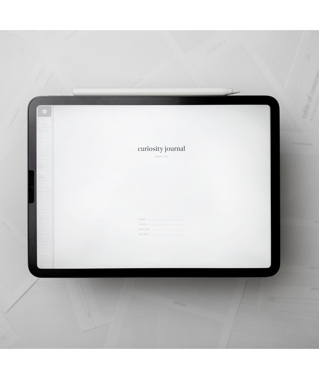 A tablet with a white background and small text in the center that says "Curiosity Journal". From Answer in Progress.