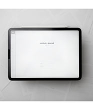 A tablet with a white background and small text in the center that says "Curiosity Journal". From Answer in Progress.