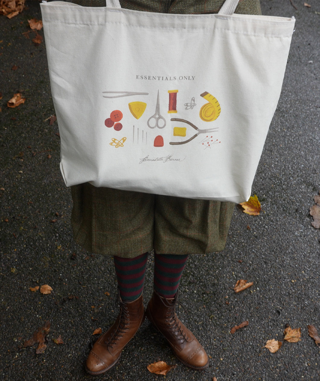 A photograph of Bernadette holding the Essentials Only Tote Bag in front of her legs.