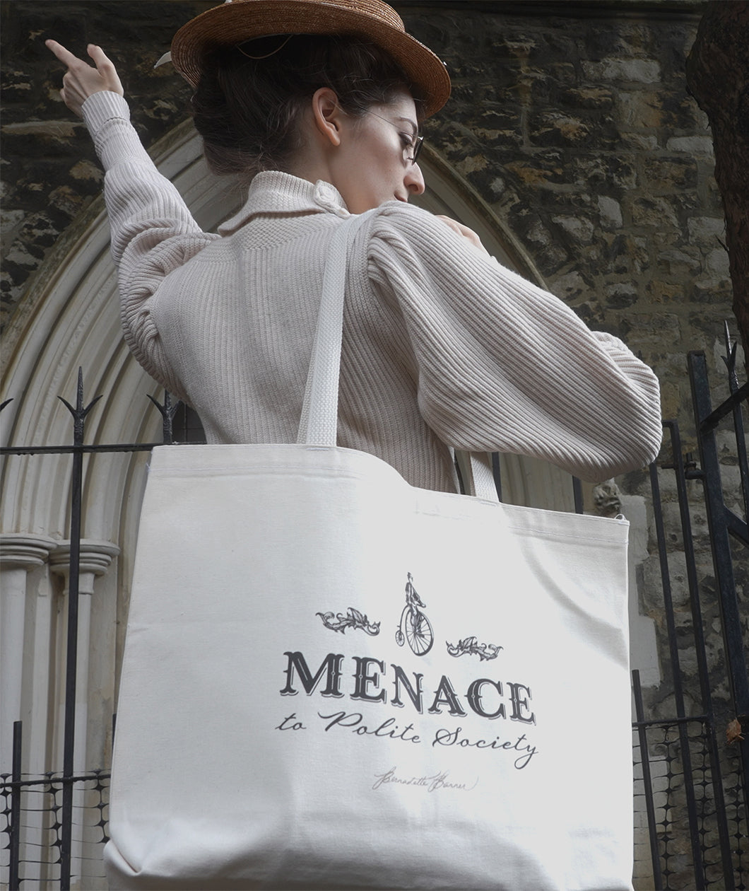A photograph of Bernadette posing showing the Menace to Polite Society tote bag over her shoulder.