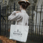 A photograph of Bernadette facing away from the camera showing the Menace to Polite Society tote bag over her shoulder.