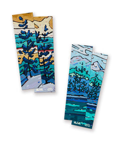 A pair of bookmarks with painted artwork on them. The artwork features heavy-paint renditions of mountainous landscapes with trees. Such scenes are of places in Nova Scotia. From Books Unbound.