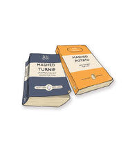 A set of 2 stickers. The first is of a blue book with a title that reads “Mashed Turnip” and the second is of an orange book with a title that reads “Mashed Potato.”