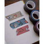 Three washi tapes of different colorways torn and taped across a page from a journal. The washi tapes come in a set of blue, purple, and brown colors. From Books Unbound.