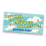 A bumper sticker that reads, "DFTBA is old enough to drive! Good luck, bestie!" The sticker has light colors of blue, green, orange, and white. From DFTBA.