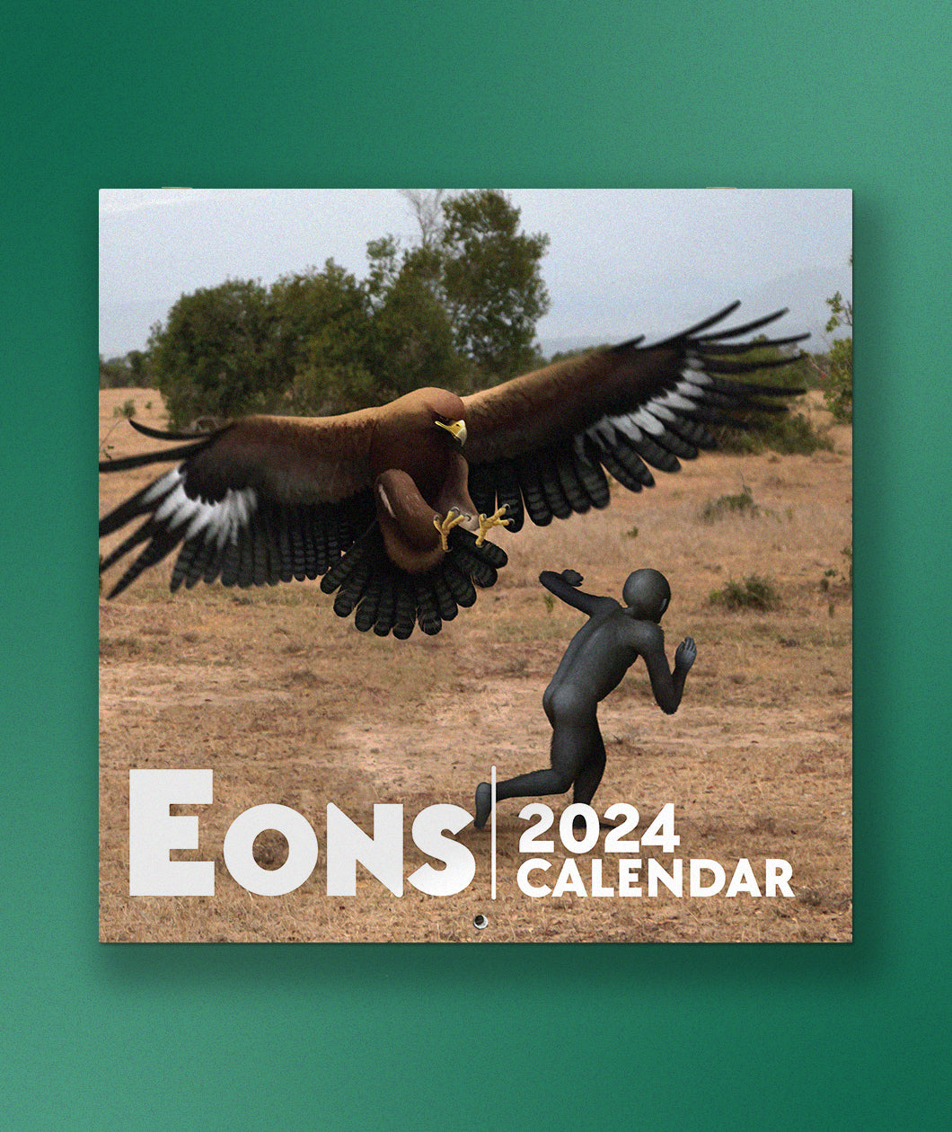 The cover of the Eons 2024 Calendar in front of a green background. The cover is a rendering of a large hawk attacking a person.  
