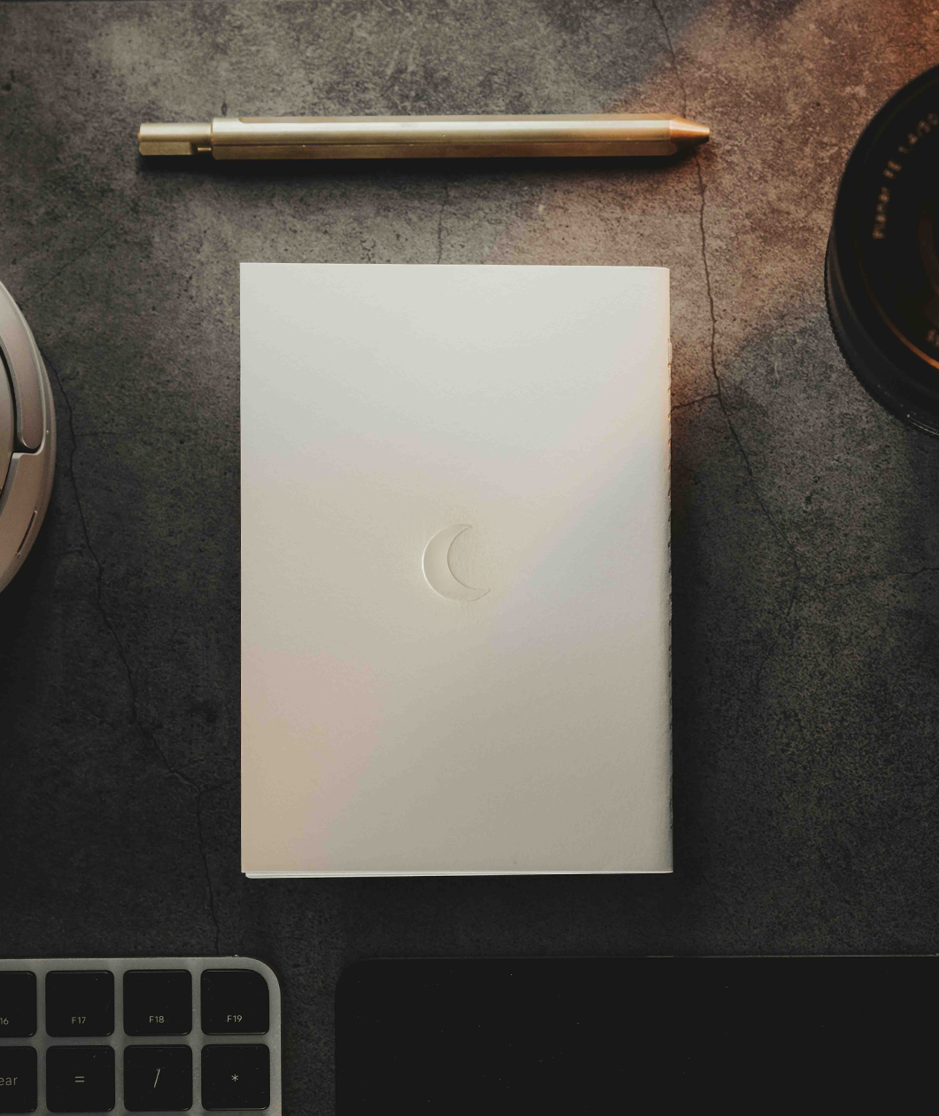 A white notebook with a printed crescent moon on the back from Lizzie Peirce.