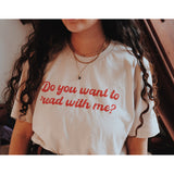 A person wearing an off-white t-shirt with cursive red text across the front that reads "Do you want to read with me?" from Middlecase.