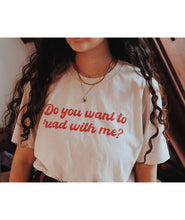 A person wearing an off-white t-shirt with cursive red text across the front that reads "Do you want to read with me?" from Middlecase.