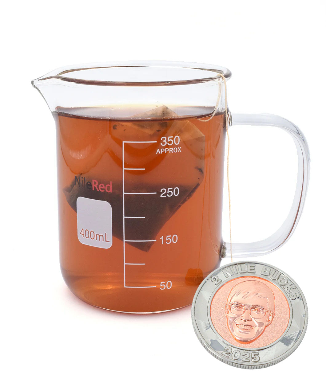 A glass beaker with a mug handle full of brown tea and a tea bag. On the side of the mug is the NileRed logo and a square that says 400mL and shows a scale of 350mL. To the side is a coin with an image of Nigel from NileRed and the text "2 Nile Bucks; 2025" with a diamond fractal pattern.