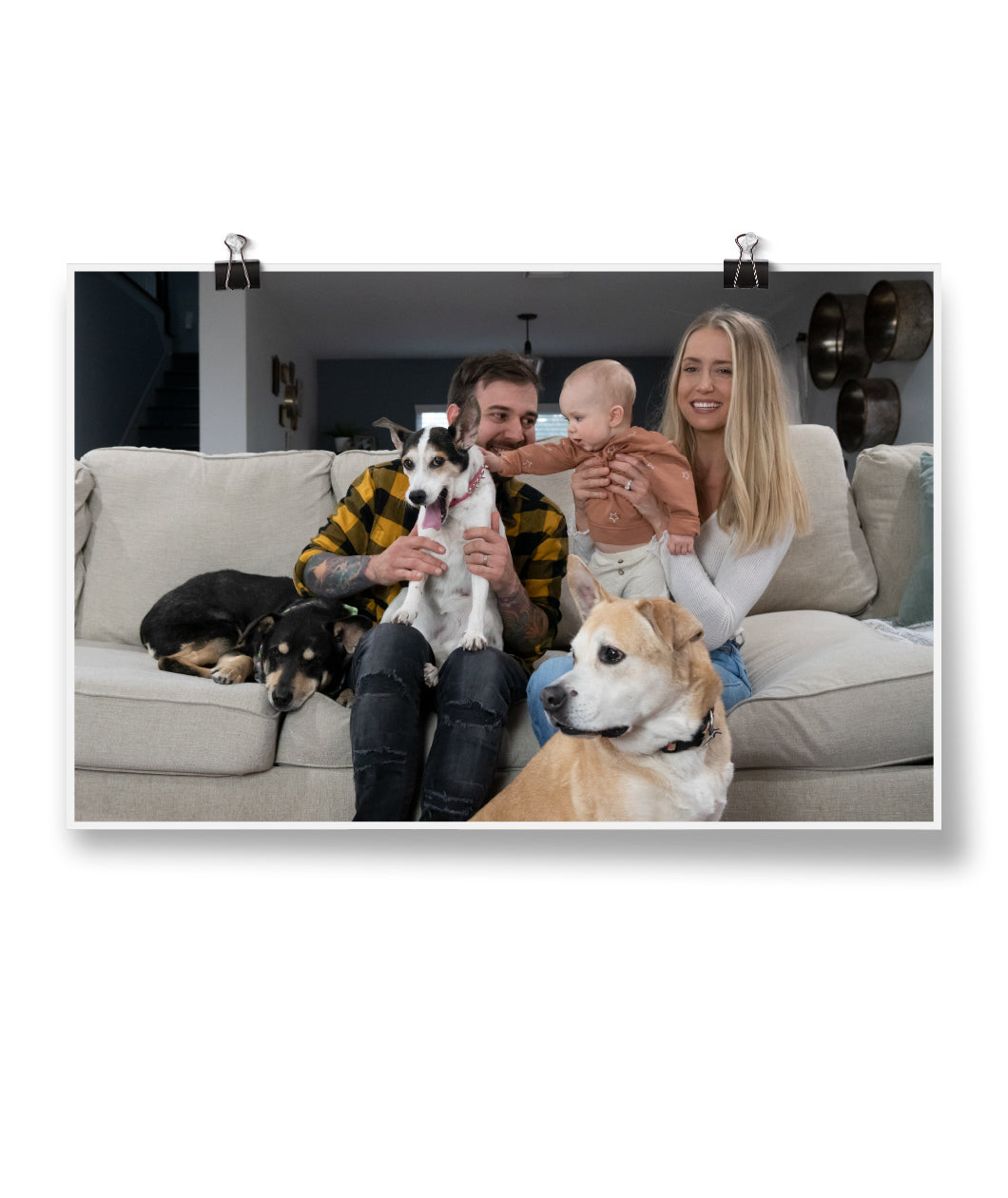 A photo of a couple, their baby, and their 3 dogs sitting on a couch - by Charles Trippy