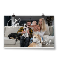 A signed photo of a couple, their baby, and their 3 dogs sitting on a couch - by Charles Trippy