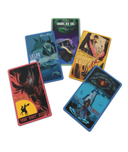 A set of five Outlaws and Obelisks rectangular tradings cards laid out. They are all different colors with different pictures on them. 