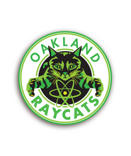 Circular sticker centering a green and black cat with the phrase "Oakland Raycats" in green lettering on a white background - by 99% Invisible