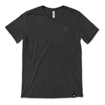 A dark grey t-shirt with a small, subtle beaker logo from CGP Grey in the top left area of the shirt. 