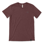 A dark red t-shirt with a small, subtle beaker logo from CGP Grey in the top left area of the shirt. 