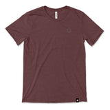 A dark red t-shirt with a small, subtle beaker logo from CGP Grey in the top left area of the shirt. 