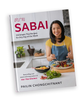 A cookbook title "Sabai" by Pailin Chongchitnant from Hot Thai Kitchen. The cover is Pailin in a kitchen tossing a meal on a plate. 