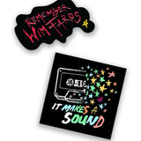 Two detached black pins. One pin with a cassette tape dissolving into colorful stars. The words "It Makes a Sound" are written below. The other pin is blob shaped with the words "Remember Wim Faros" written in red and a small yellow star.