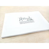 A flat, thin, white book with the words "Hokkaido in ink." above "Sopporo, Otaru & Hakodate 2019 travelogue by Mateusz Urbanowicz" in black writing. 