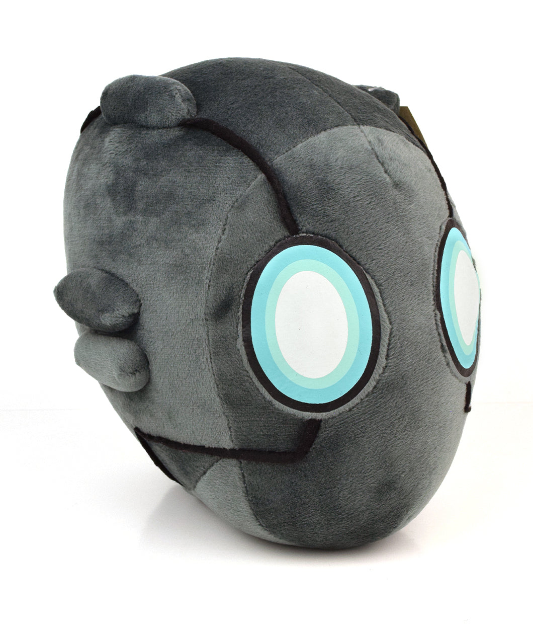 Gray robot head plushie. Shape is ovular in the front and oblong in the back. There are black accent lines and three ovular shapes on the left side of the head. Two eyes are in the front with a blue, light blue, and white fill - from Tesladyne