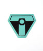 A black upside down triangular sticker with a thick teal outline and squared off edges. A teal “T” is in the center with a black octagon in the center and a teal circle in the center of that - from Tesladyne