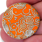 A NileRed circular orange pins showing abstract lines being held in someones fingertips.