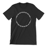 A black t-shirt that has text in a circle that reads "Put in the miles so you can " repeating twice with an arrow in between. From Semi Rad. 