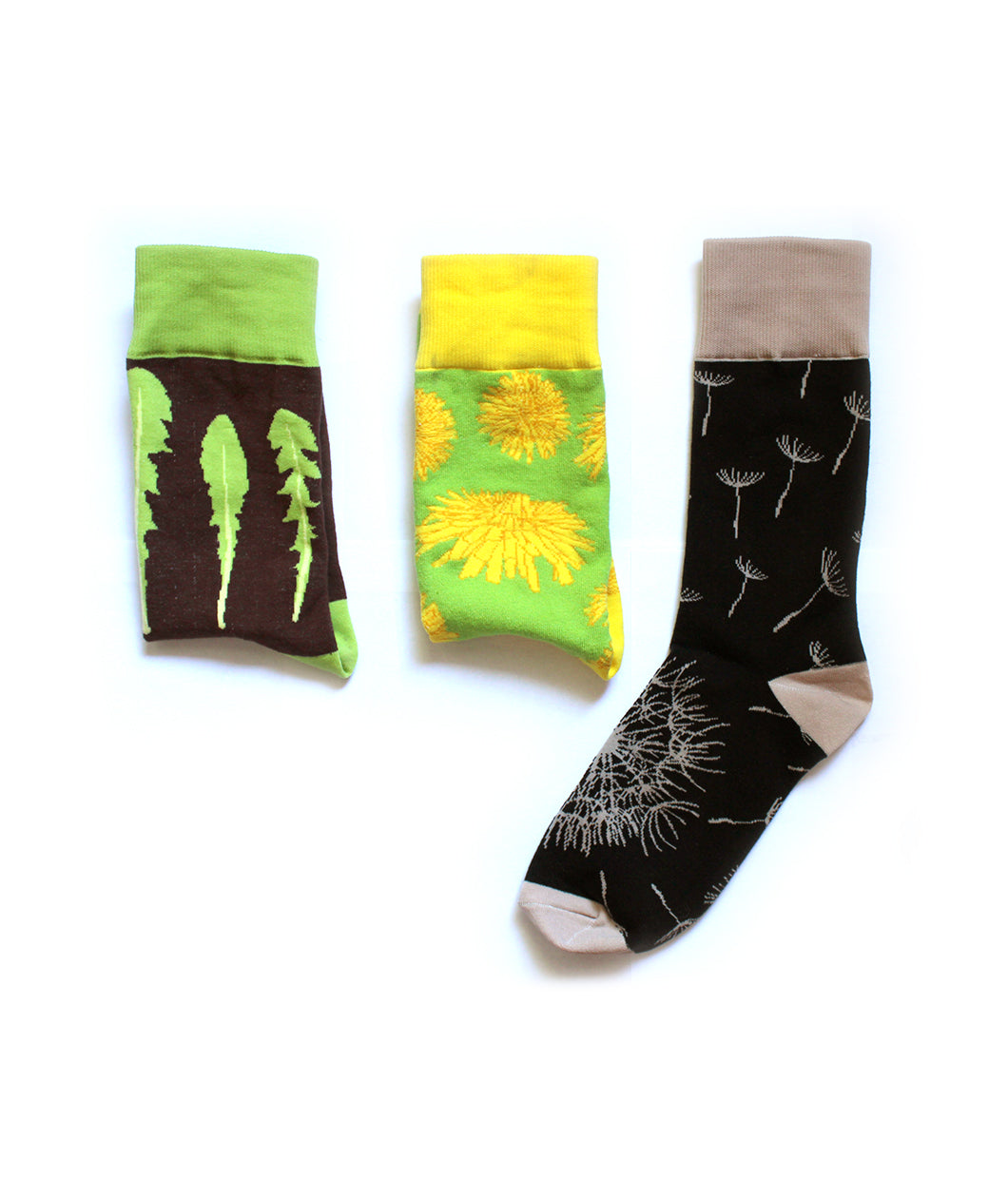 A set of three different socks. First: Brown sock folden in half with a green ankle and three leaves. Second: Light green sock folded in half with yellow ankle with a varying styles of yellow dandelions. Third: A black sock with tan ankle, heel, and toe dandelion multiple dandelion seeds floating away from dandelion - from This Star Won’t Go Out