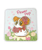 Enamel pin of an orange and white puppy sitting on the ground, looking over its should. The puppy has pink flowers around its head, and it wears a pink bow. The pin is on a square backing card that depicts a field of flowers, with the text "Flower Pup." By What's Up Beanie.