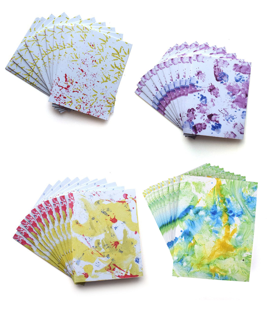 Four different styles of greeting cards. Each style has multiple cards fanned out behind. Top left: Yellow bird footprints and red sprinkle of seeds. Top right: Purple and blue footprints made by skunk and cavy. Bottom left: Primarily yellow paint with red streaks and smattering of blue made by beaver. Bottom right: Primarily green paint with yellow and blue swooshes made by two lizards and two snakes - from Animal Wonders