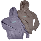Two hoodies laying side by side, one is purple and one is grey/brown. Both are embroidered in light blue with the words "I'm thinking about books." across the chest and a small book on the right cuff.