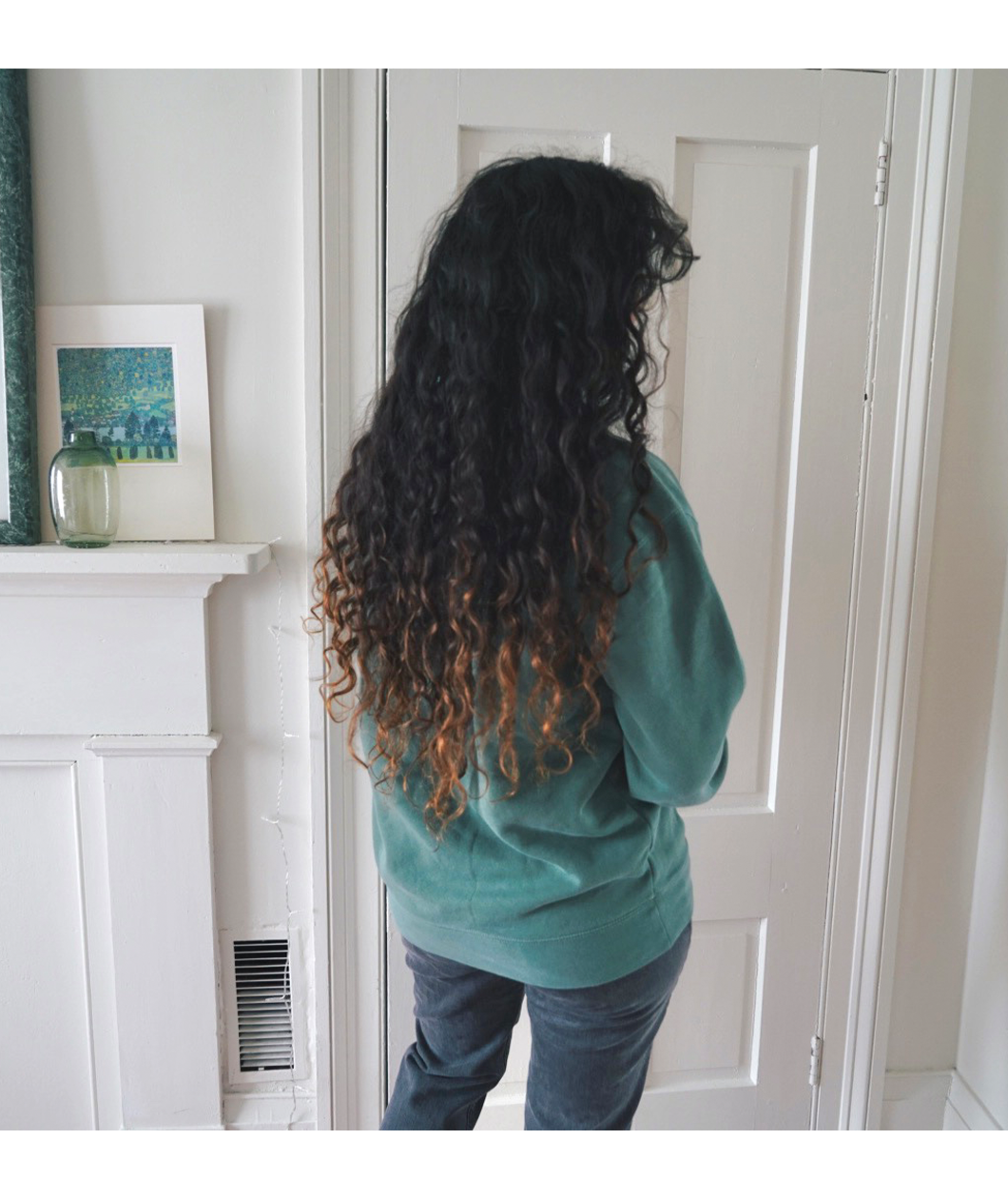 Ariel Bissett modeling the back of an alpine green sweatshirt.