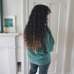 Ariel Bissett modeling the back of an alpine green sweatshirt.
