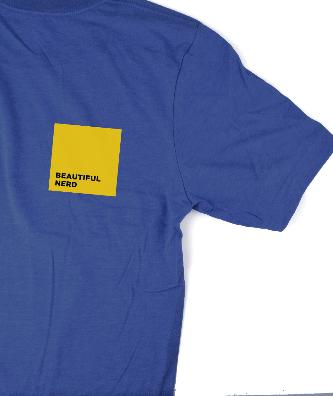 Part of a royal blue t-shirt that has a yellow square with the words "Beautiful Nerd" inside it - by 99% Invisible
