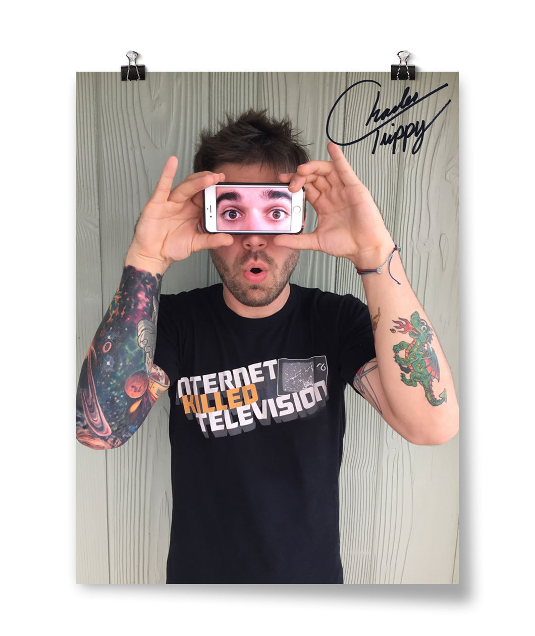 A signed photo of Charles Trippy holding an iphone showing a photo of eyes over his eyes
