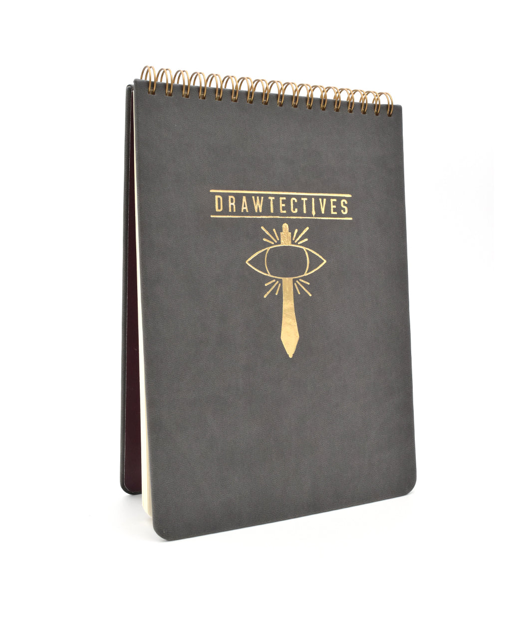 A large black sketchbook with gold spirals at the top and the word "drawtectives" with a drawing of a sword and an eye in gold in the center - by Drawfee