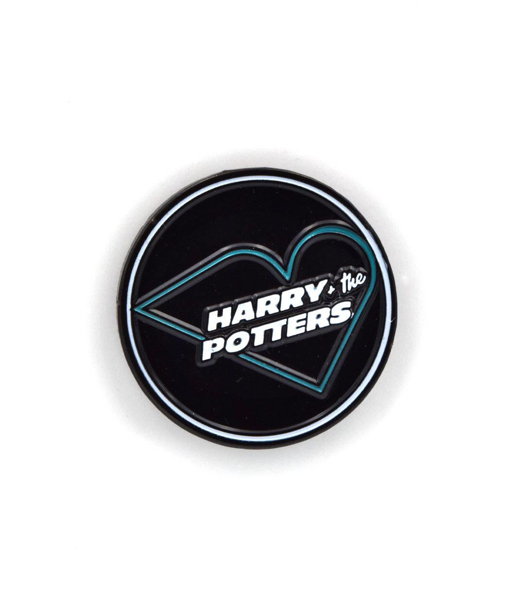 A circular pin with a black background and white outline. It features a teal heart with the white text 
