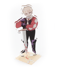 A standee of a person holding a sword with the tip to the ground with blood on it. 