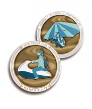 The "JoCo Cruise 2022; March 5-12" challenge coin. One side features a person on a jet ski with a guitar on their back. The other side features a turtle on a glider.