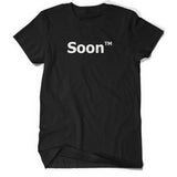 A black shirt with “Soon” in white sans serif font across the front. Following the word is “TM” at the top right of the word in white sans serif font - from JoCo Cruise