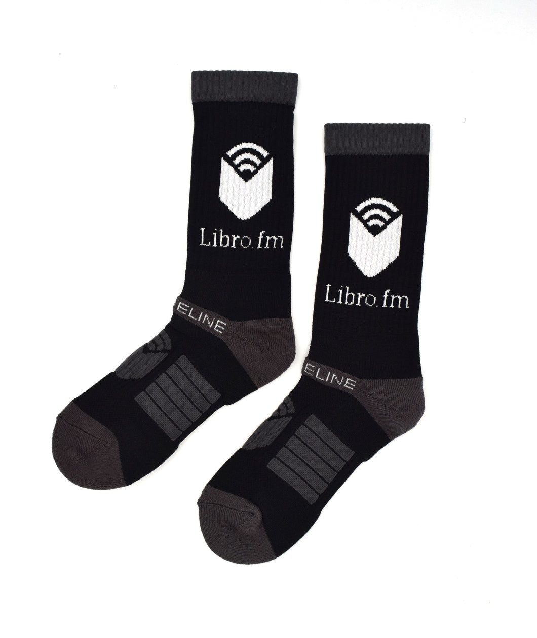 Black socks with a gray ankle, heal, and toe with gray rectangular lines on the toe with a gray open book on the top of the toe. “Libro.fm” is on the top of the sock in white serif font. Above is a white open book - from Libro.fm