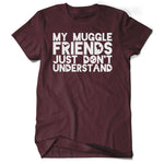 A dark red shirt with “My Muggle Friends Just Don’t Understand” in white sans serif font. Dark red silhouettes of lightning bolts, snitch, stars, and Deathly Hallows logo are in negative space of some letters - from Lauren Fairweather