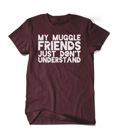 A dark red shirt with “My Muggle Friends Just Don’t Understand” in white sans serif font. Dark red silhouettes of lightning bolts, snitch, stars, and Deathly Hallows logo are in negative space of some letters - from Lauren Fairweather