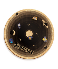 A round cork board with shades of black, showing the different planets with different Scishow Space pins attached. It says "Scishow Space" on the outer edge.