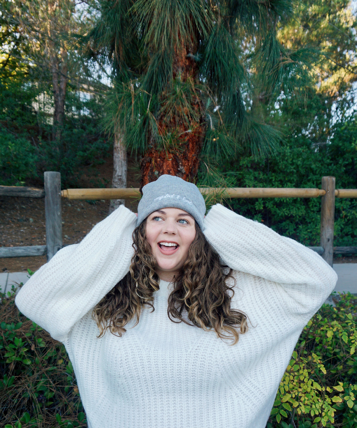 A woman modeling a gray beanie with “confident & kind” in white cursive font across the cuff - from Sierra Schultzzie