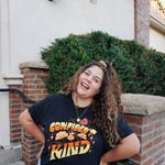 A girl modeling a blue shirt with “Confident & Kind” in half yellow and half orange organic fond. The words are surrounded by various flowers and stars - from Sierra Schultzzie