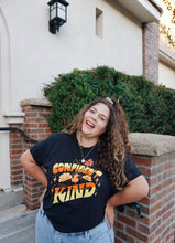A girl modeling a blue shirt with “Confident & Kind” in half yellow and half orange organic fond. The words are surrounded by various flowers and stars - from Sierra Schultzzie