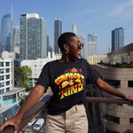A girl modeling a blue shirt with “Confident & Kind” in half yellow and half orange organic fond. The words are surrounded by various flowers and stars - from Sierra Schultzzie